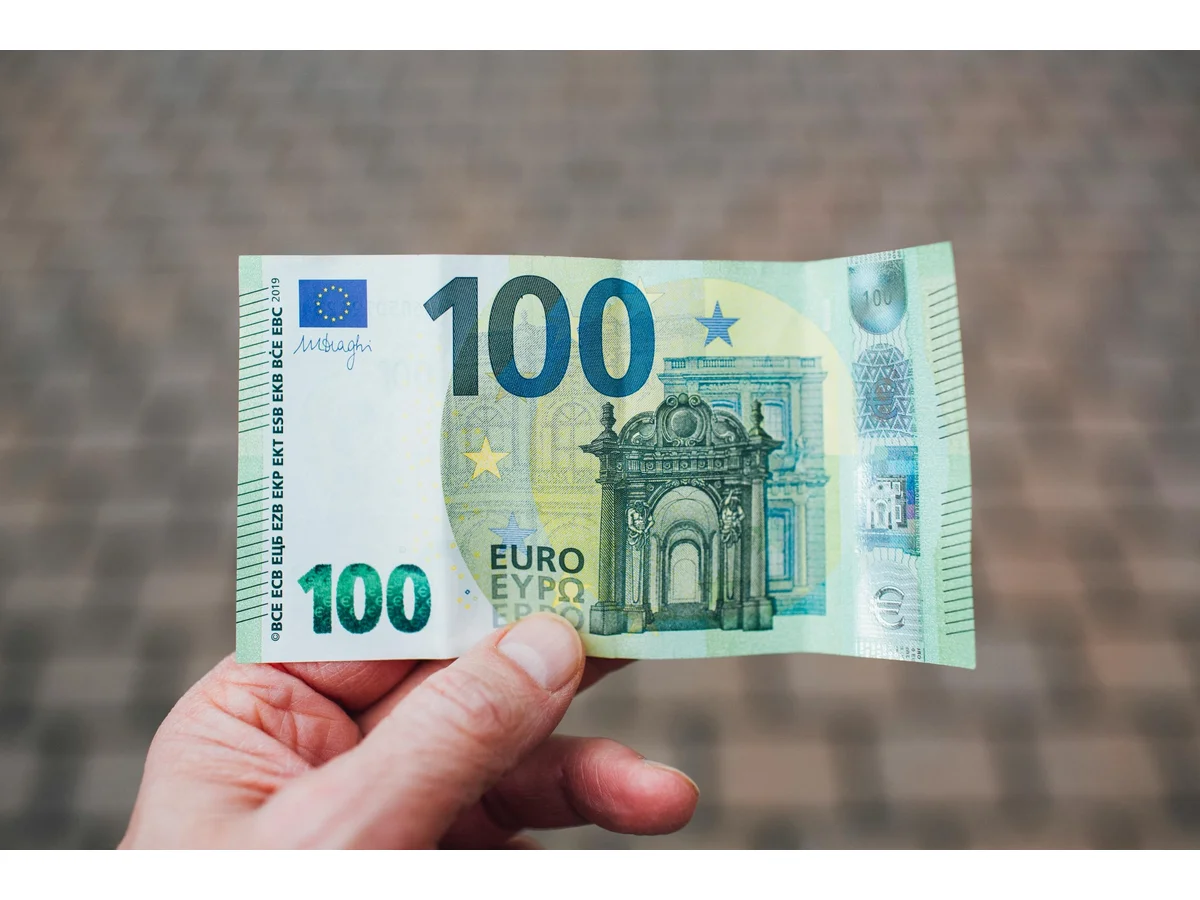 Billet de 100 euros dans une main