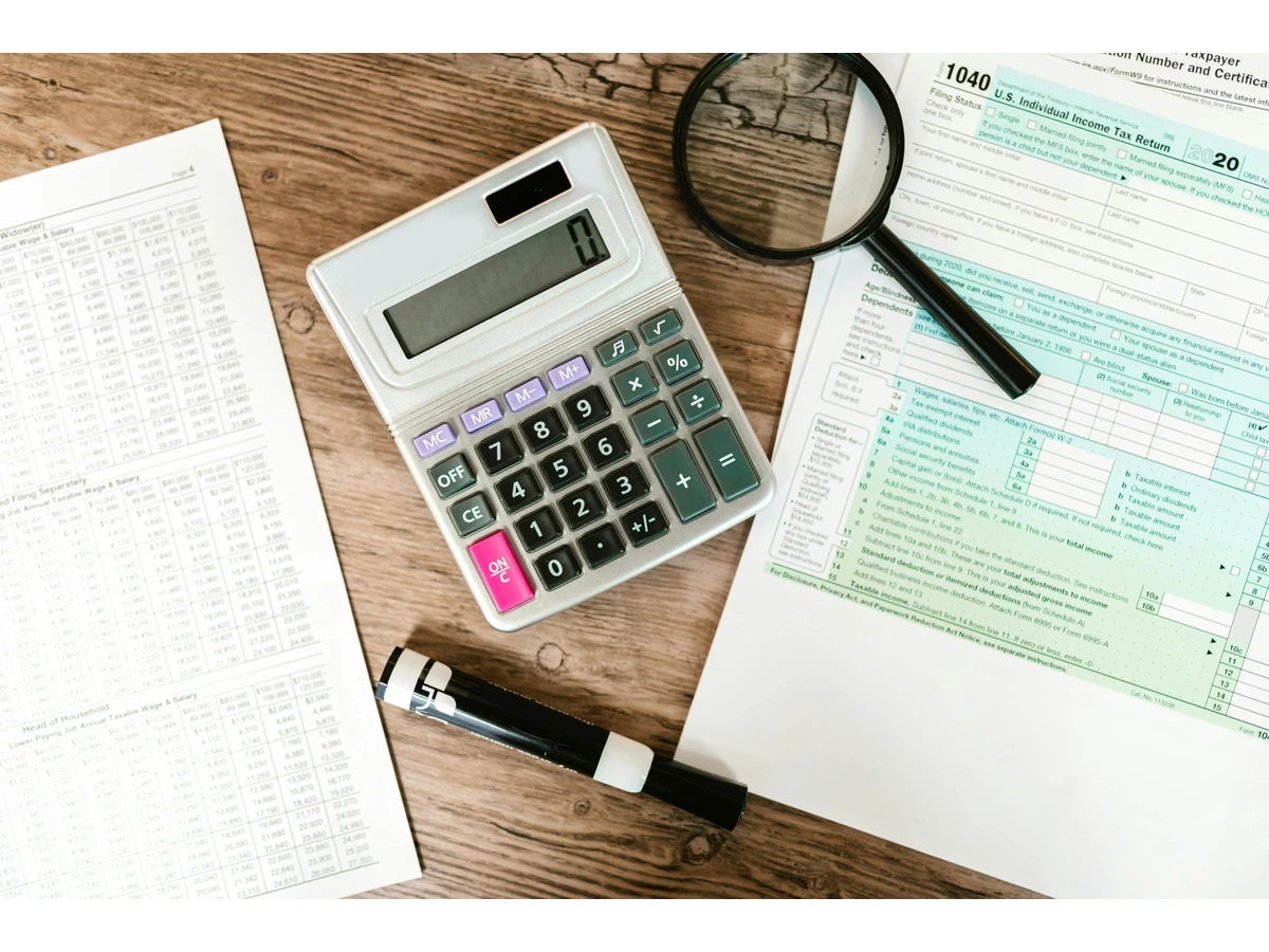 Feuille déclaration d'impôts avec une calculatrice et une loupe